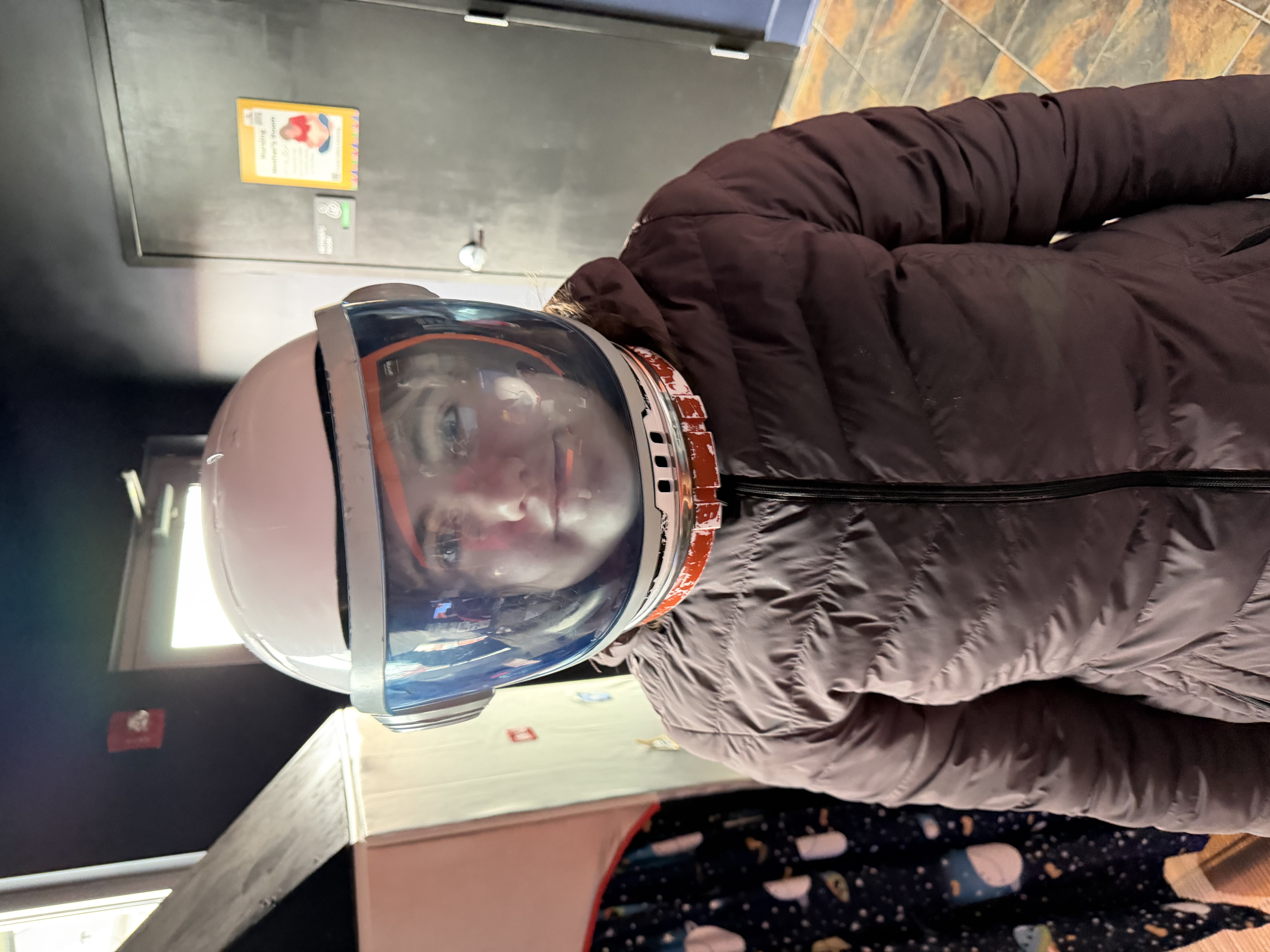 Participant trying on astronaut helmet at museum